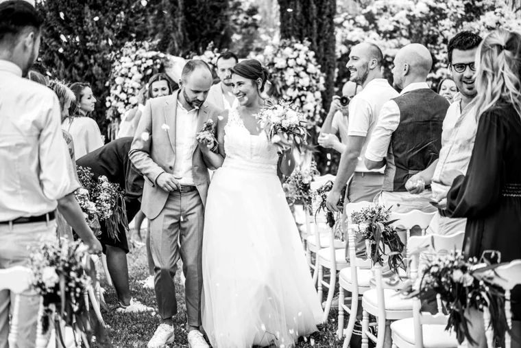 Newlyweds walking between wedding guests