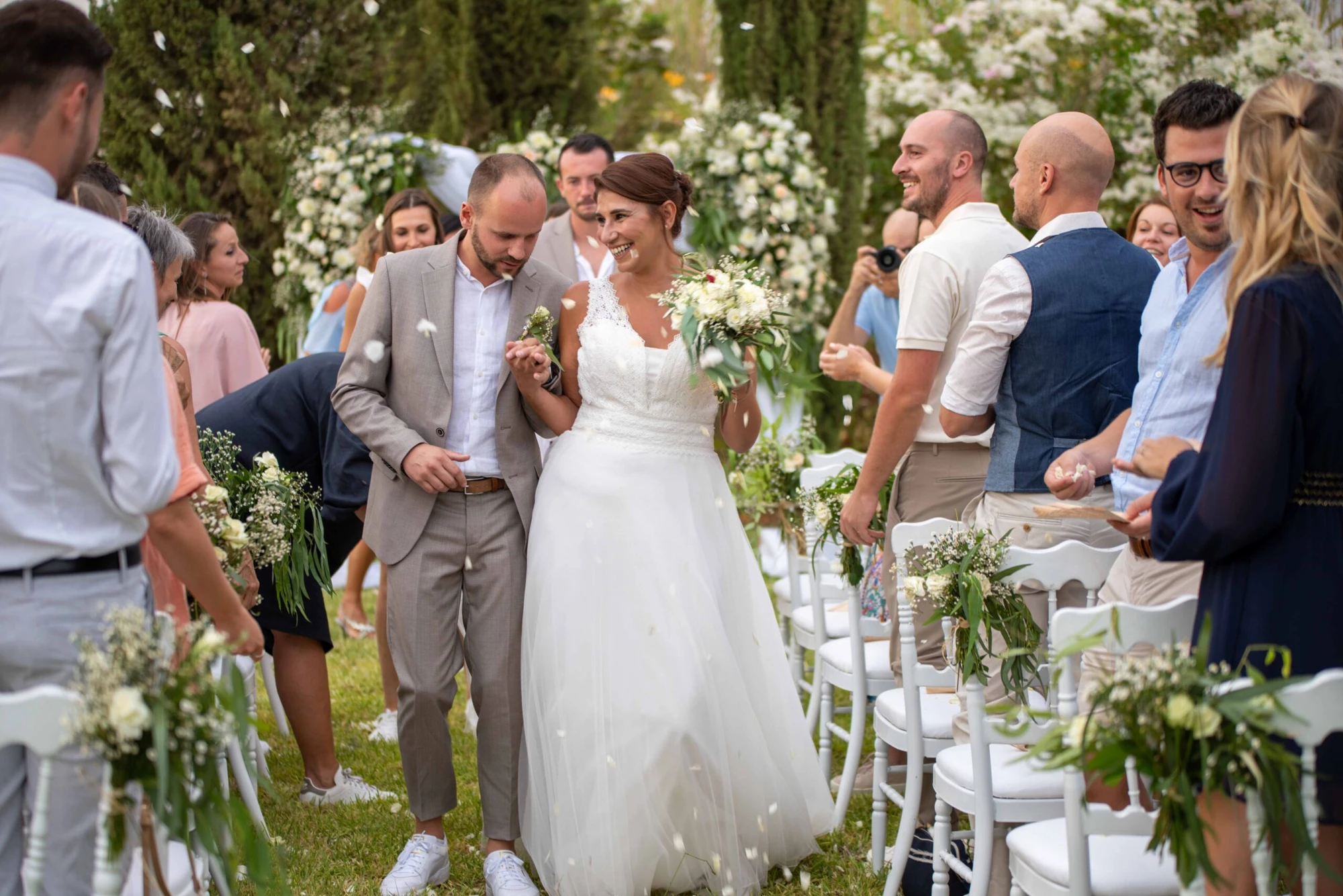 Newlyweds walking between wedding guests