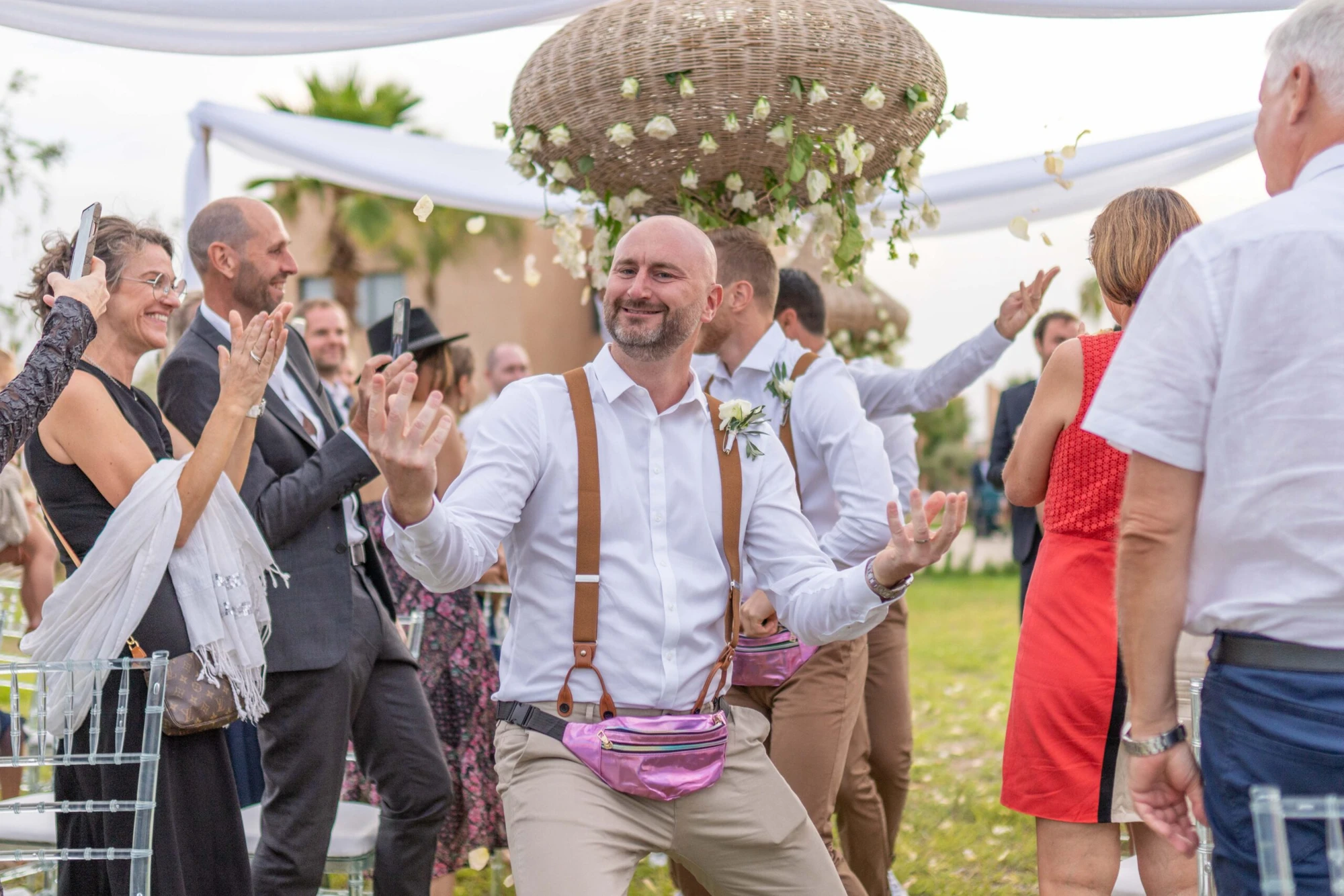 Wedding celebration with guests tossing petals around the couple