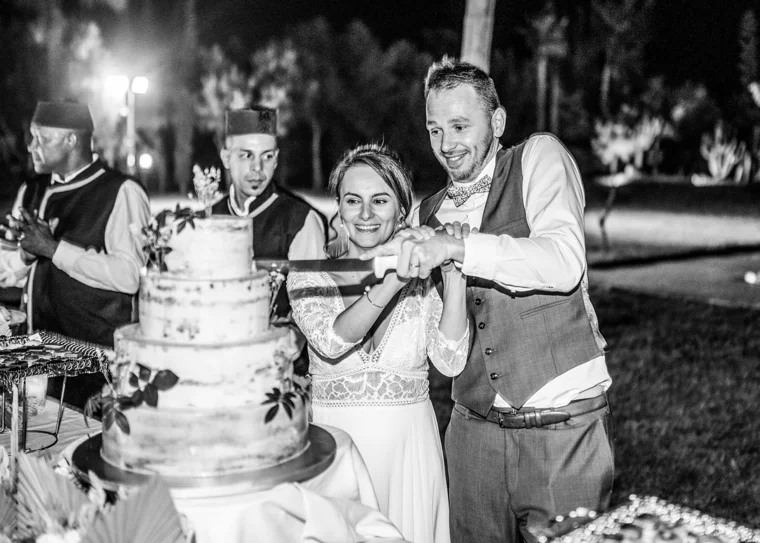 Couple cutting their wedding cake at night
