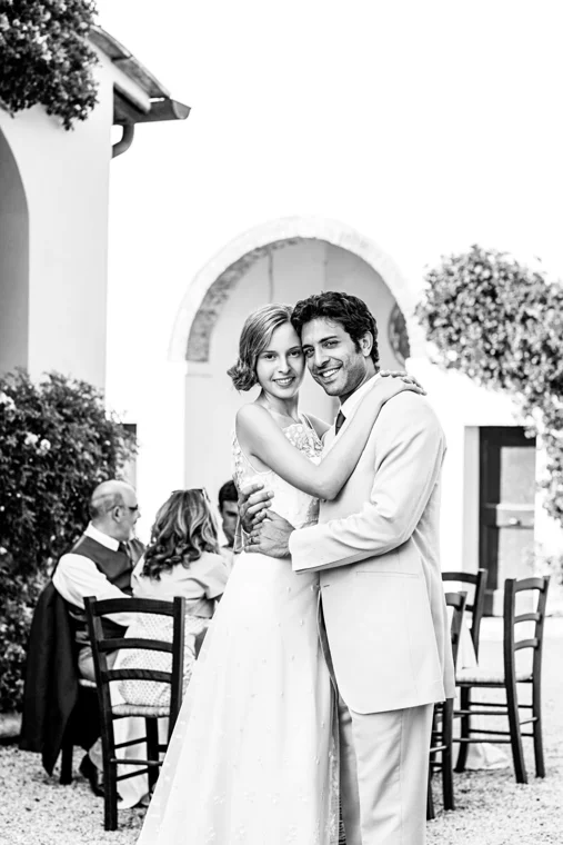 Couple embracing by a flower-filled arch