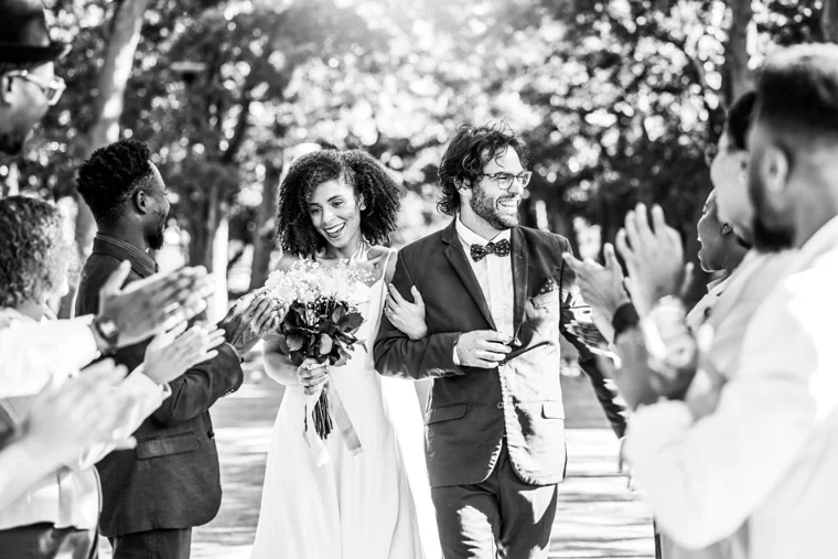 Wedding couple walking past applauding guests