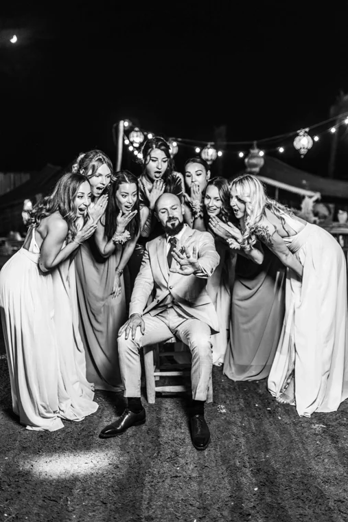 Wedding party posing under string lights
