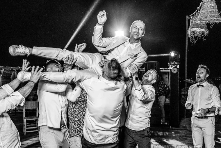 Guests lifting the couple at a reception