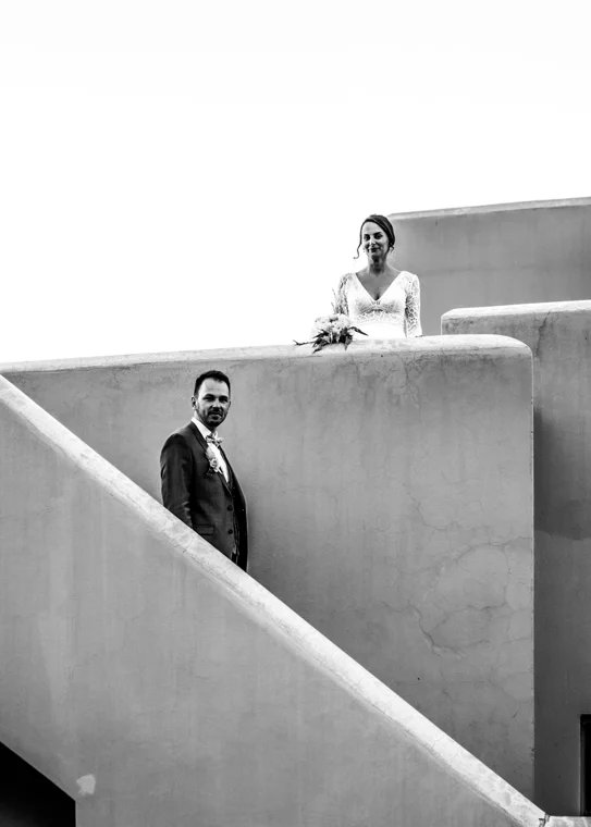 Couple framed by warm pink architecture