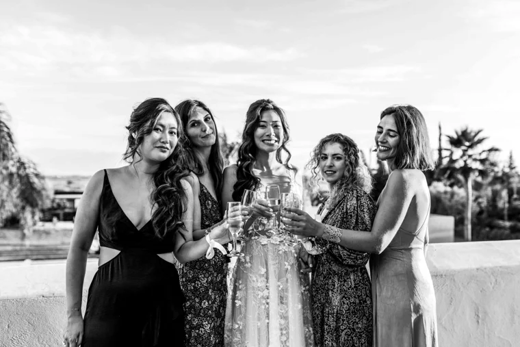 Wedding guests raising glasses outdoors