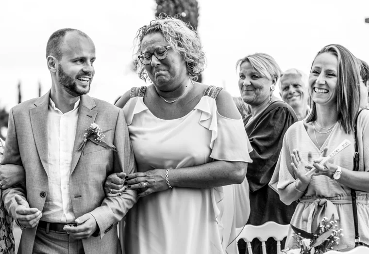 Groom smiling alongside wedding guests