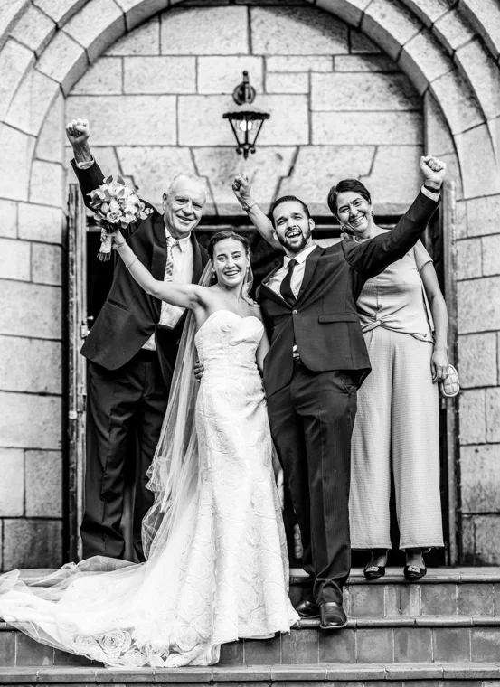 Newlyweds celebrating at an arched doorway