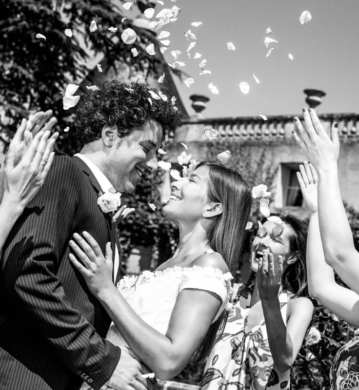 Newlyweds celebrating beneath falling petals